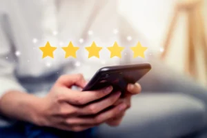 person holding a phone with a graphic of five stars above it