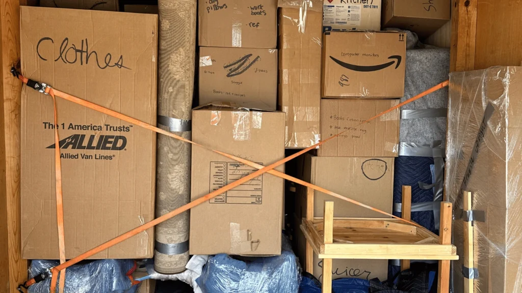 Experienced movers packing cardboard boxes with household items in Charlestown, MA