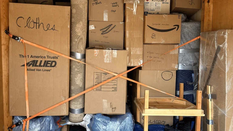 Experienced movers packing cardboard boxes with household items in Charlestown, MA