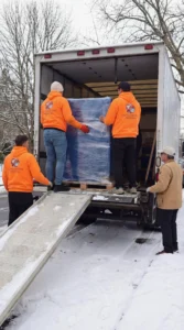 Professional movers loading protected furniture into moving truck